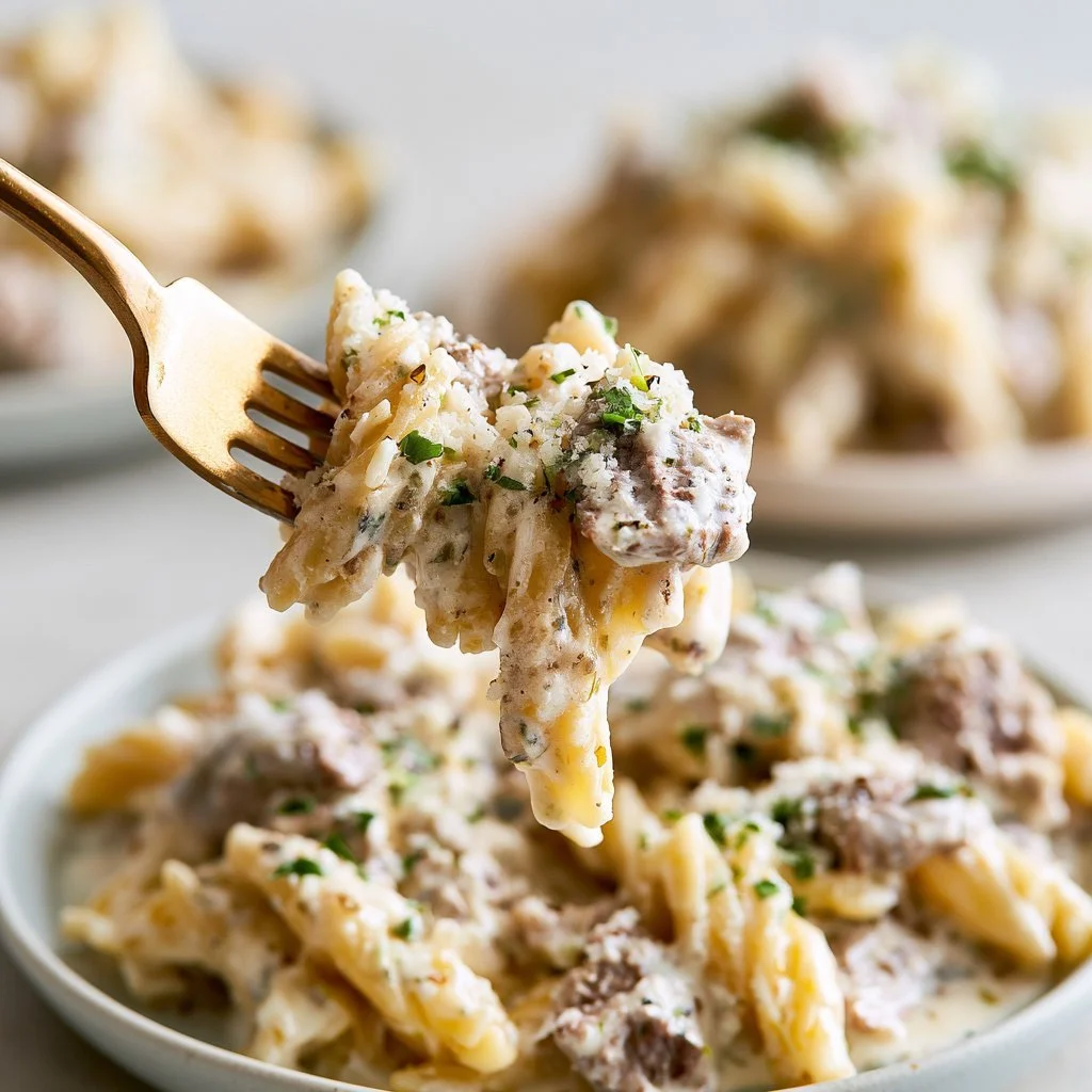 Creamy beef pasta in a bowl with fresh herbs and cheese